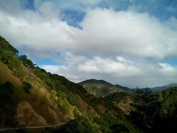 Scenic view of mountains against cloudy sky