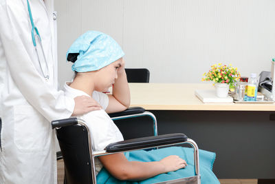 Boy sitting on chair at home