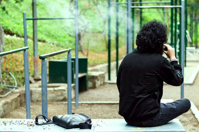 Rear view of man smoking outdoors