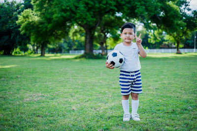 Full length of girl playing soccer on field