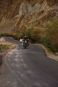 People riding motorcycle on road