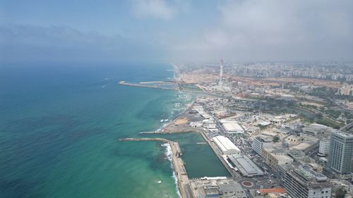 High angle view of city by sea against sky