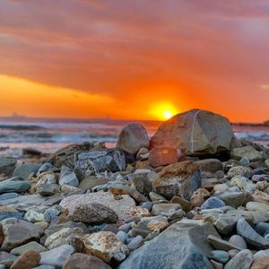 Rocks on beach during sunset