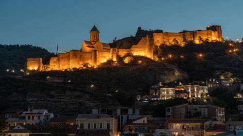 Illuminated buildings against sky at night