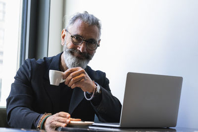 Smiling male professional having coffee at cafe