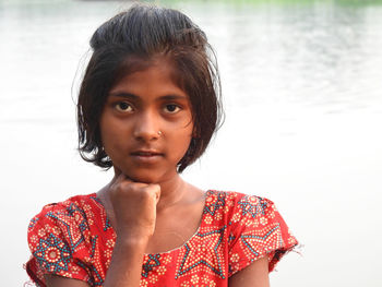 Portrait of young woman against lake