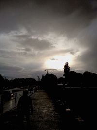 Silhouette of trees against cloudy sky