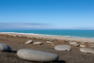 Scenic view of beach against clear blue sky