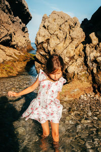 Rear view of woman standing on rock