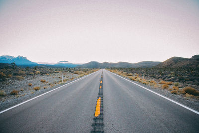 Empty road along countryside landscape