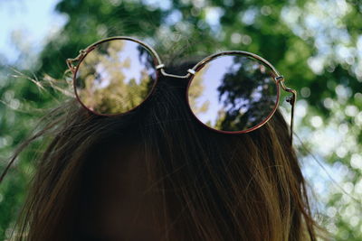 Close-up portrait of woman against sunglasses