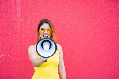 Portrait of woman standing against wall