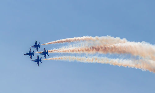 Low angle view of airplane flying against blue sky