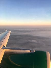 Cropped image of airplane flying over cloudscape