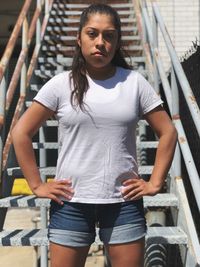 Portrait of young woman standing against built structure