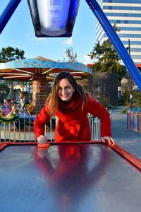 Portrait of smiling young woman playing air hockey