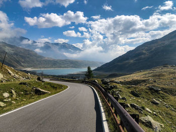 Road leading towards mountains against sky