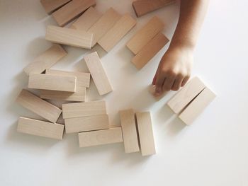 Cropped image of child playing with toy blocks on white background