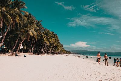 People at beach against sky