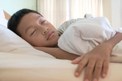 Midsection of man sleeping on bed