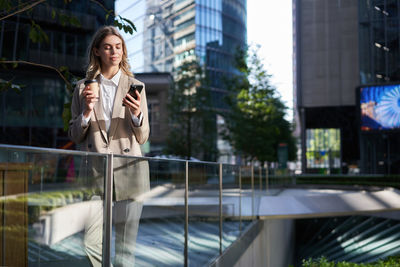 Portrait of young woman standing in city