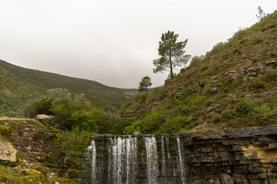 Scenic view of waterfall against sky