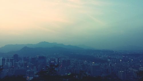 Cityscape against cloudy sky