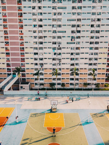 HIGH ANGLE VIEW OF PEOPLE IN SWIMMING POOL AGAINST BUILDINGS