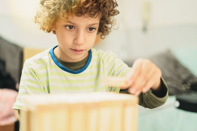 Portrait of boy holding camera at home