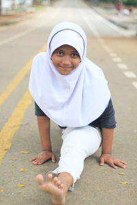 Portrait of girl in traditional clothing practicing taekwondo on road