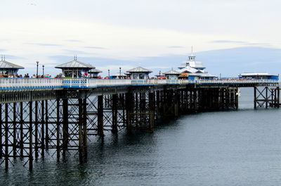 Pier on sea against cloudy sky