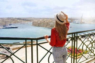 Back view of beautiful girl enjoying view of three cities from upper barrakka gardens valletta malta