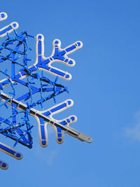 Low angle view of ferris wheel against clear blue sky