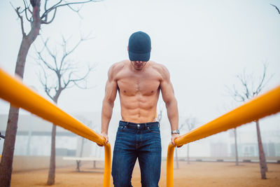 Man in cap doing triceps exercises in a calisthenics park