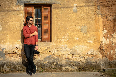 Full length of man standing against wall