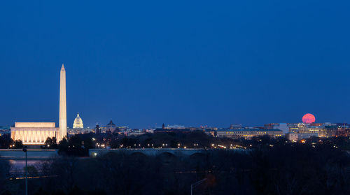 Illuminated buildings against blue sky