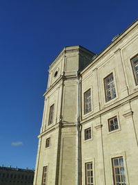 Low angle view of old building against clear blue sky