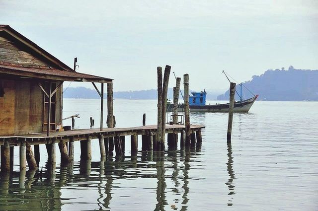 water, sea, wood - material, pier, wooden post, sky, tranquility, tranquil scene, built structure, waterfront, horizon over water, nature, wood, nautical vessel, scenics, boat, day, clear sky, moored, beauty in nature