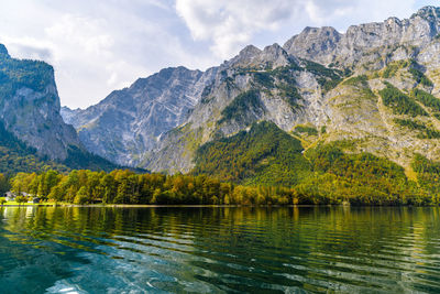 Scenic view of lake by mountains against sky