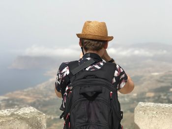 Rear view of backpacker standing against sky