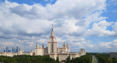 Buildings in city against cloudy sky