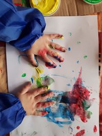 Cropped hand of child drawing at table