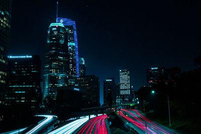 Illuminated city buildings against sky at night