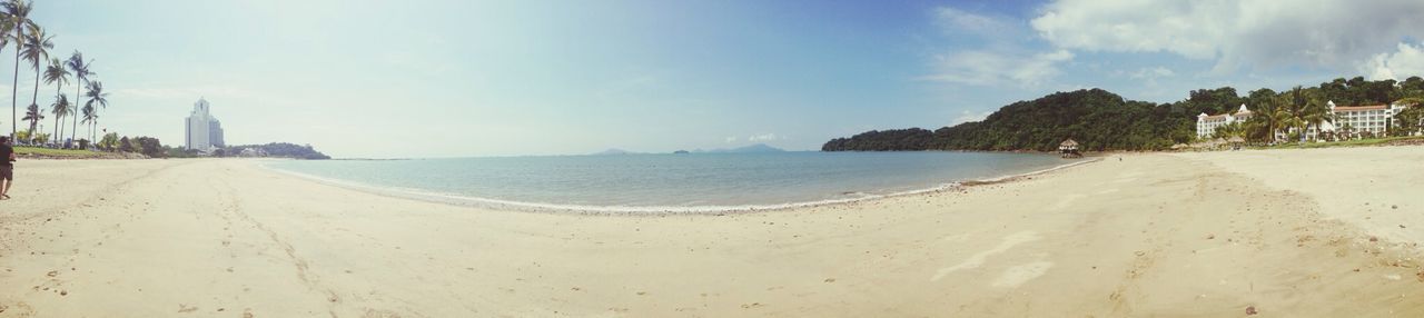 sea, beach, sand, water, sky, shore, horizon over water, tranquil scene, panoramic, scenics, tranquility, incidental people, beauty in nature, coastline, nature, built structure, day, idyllic, architecture, building exterior