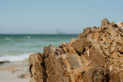 Close-up of rocks on beach against clear sky