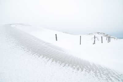 Scenic view of snow covered field against clear sky