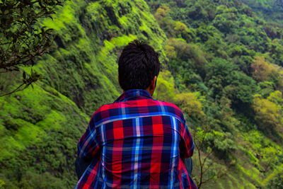 Rear view of man against trees in forest