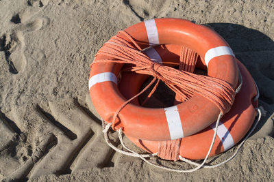 Orange lifebuoys with ropes on the sand