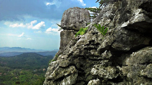 Low angle view of rocks on mountain against sky