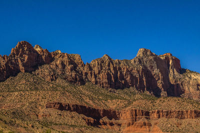 Low angle view of rock formation against clear blue sky